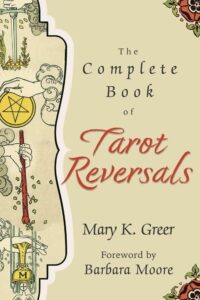 The Complete Book of Tarot Reversals by Mary K Greer | Cream background with the ace of pentacles held by a hand and ace of wands art